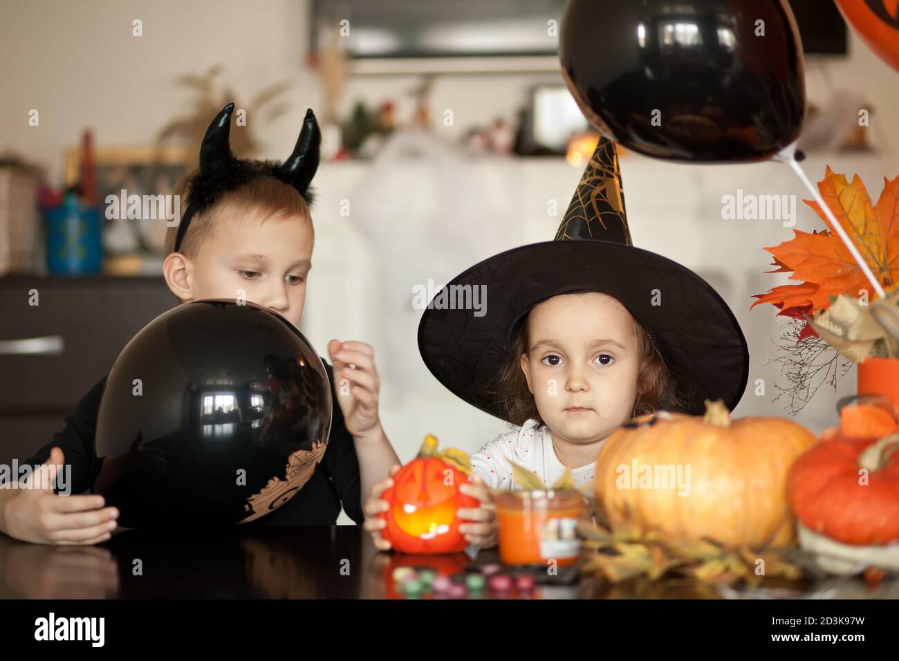 funny child girl and boy in witch and evil costumes for Halloween have fun. Stock Photo