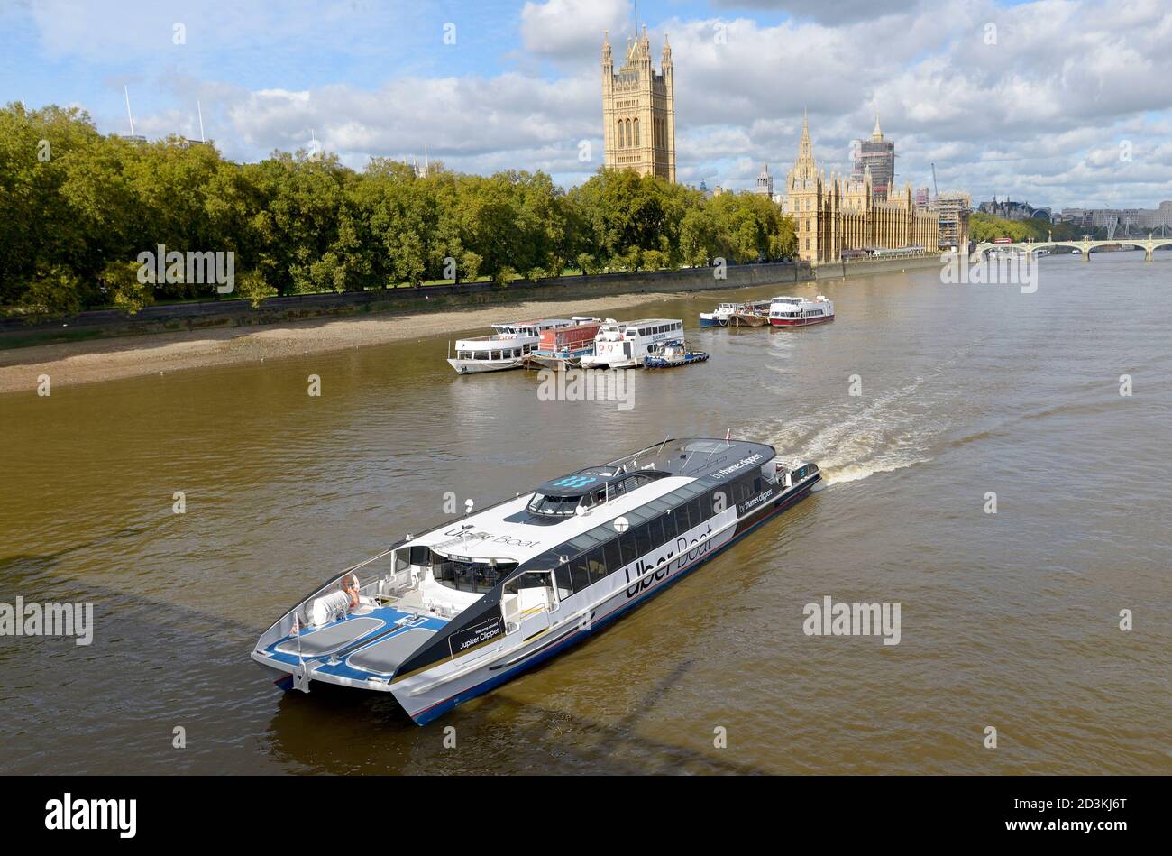London, England, UK. Uber Boat - by Thames Clipper, passing the Houses of Parliament. Jupiter Clipper, rebranded August 2020 Stock Photo