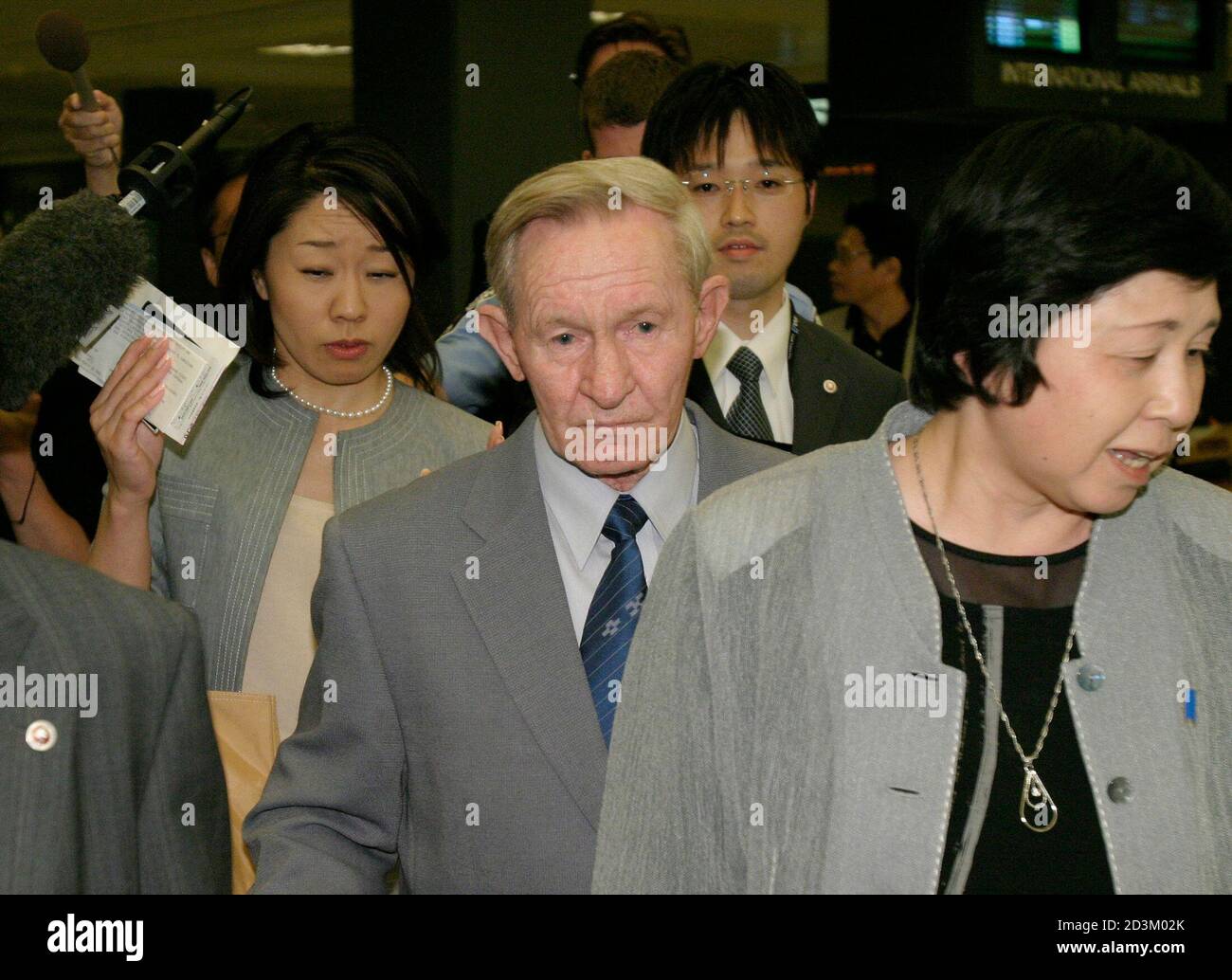 Former U.S. Army deserter Charles Jenkins (C) walks past members of the news media after arriving at Washington Dulles International Airport in Dulles, Virginia June 14, 2005. Jenkins, 65, deserted to North Korea from South Korea during the Cold War and now lives in Japan with his wife. This is Jenkins' first trip to the U.S. in 40 years which he reportedly intends to spend visiting his elderly mother in North Carolina. REUTERS/Shaun Heasley SH/KI Stock Photo