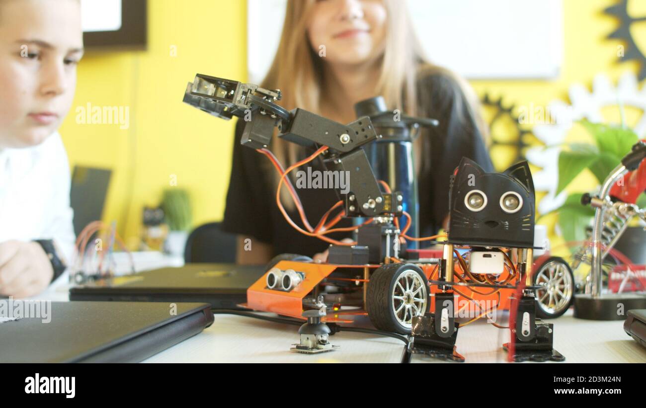 Crop teenager playing with modern robot in class Stock Photo - Alamy