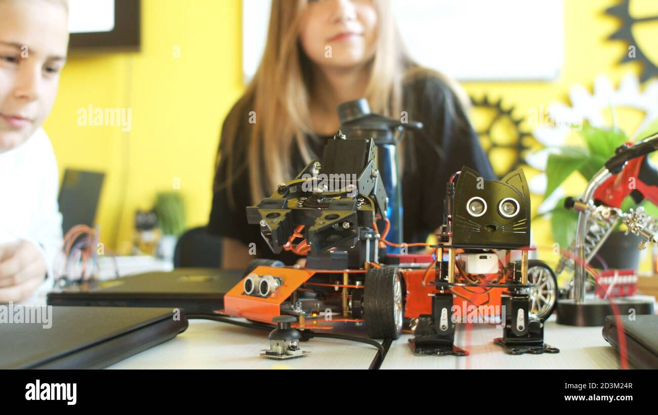 Crop teenager playing with modern robot in class Stock Photo - Alamy