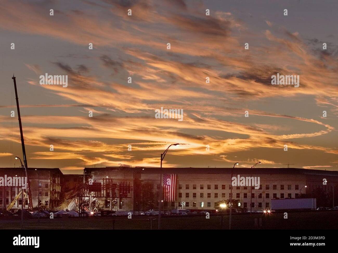 Jet contrails are seen in the early morning over Washington as the damaged area of the Pentagon Building where a commercial jetliner slammed into it September 11 sits in the foreground at sunrise, September 17, 2001. The U.S. military said on September 15 that it would cost 'hundreds of millions' of dollars to repair the damage after the hijacked jetliner struck its 48-year-old Pentagon headquarters. REUTERS/Larry Downing  LSD/SV Stock Photo