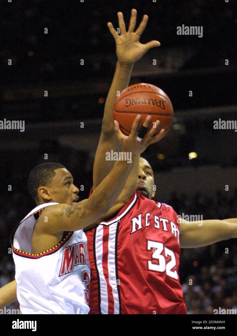 Maryland's Juan Dixon goes in under NC State's Jordan Collins (32) for