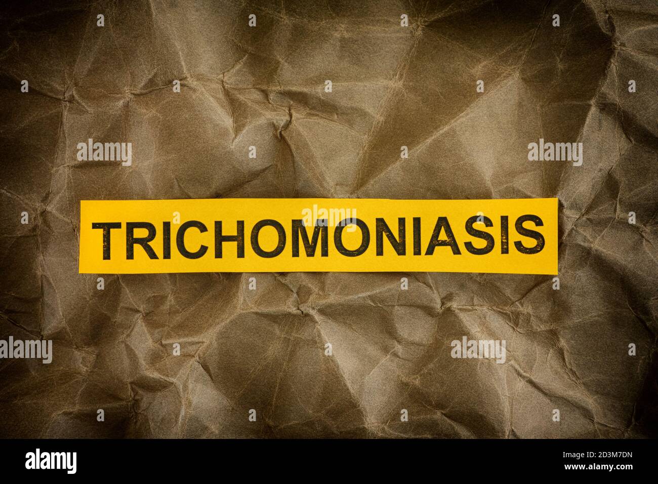 Trichomoniasis. Yellow piece of paper with the word Trichomoniasis. Close up. Stock Photo