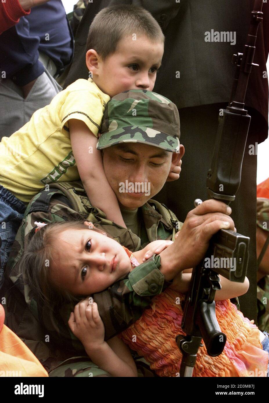 A newly conscripted Colombian soldier is hugged by his younger brother and his sister in Guasca, in the province of Cundinamarca, June 16, 2003. Some 10,000 new peasant soldiers will be sworn into duty across the country on Monday. The Colombian army capturing 58 suspected Marxist guerrillas in weekend raids and said on Monday it believed the operation had dealt a blow against rebel plans to carry out attacks in the capital. Those held are alleged members of the Revolutionary Armed Forces of Colombia, a 17,000-strong force known by the Spanish initials FARC. REUTERS/Daniel Munoz  EM/GN Stock Photo