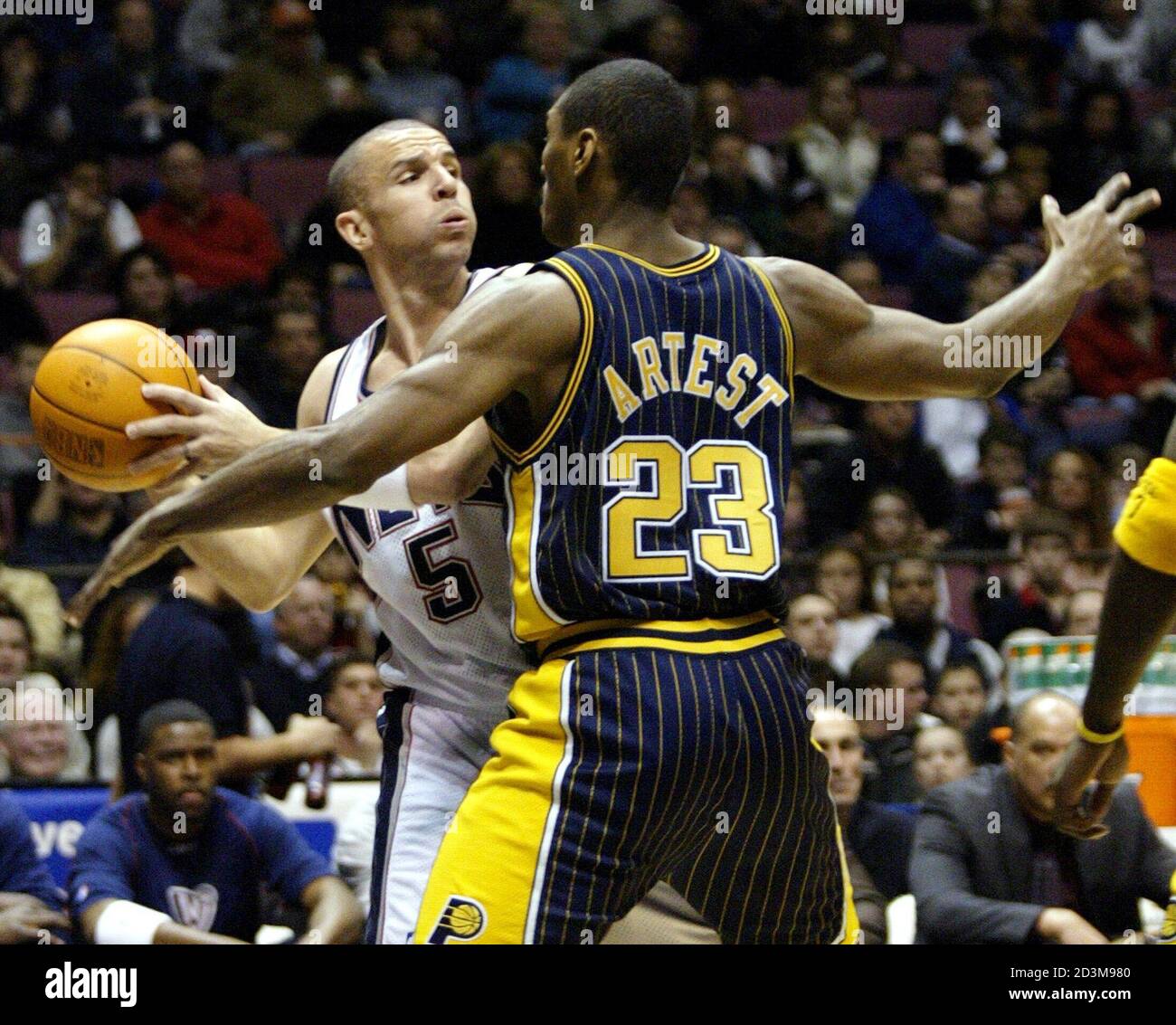 New Jersey Nets guard Jason Kidd (L) looks to pass the ball around Indiana  Pacers forward Ron Artest, in the first period of their NBA game January  17, 2004 in East Rutherford,
