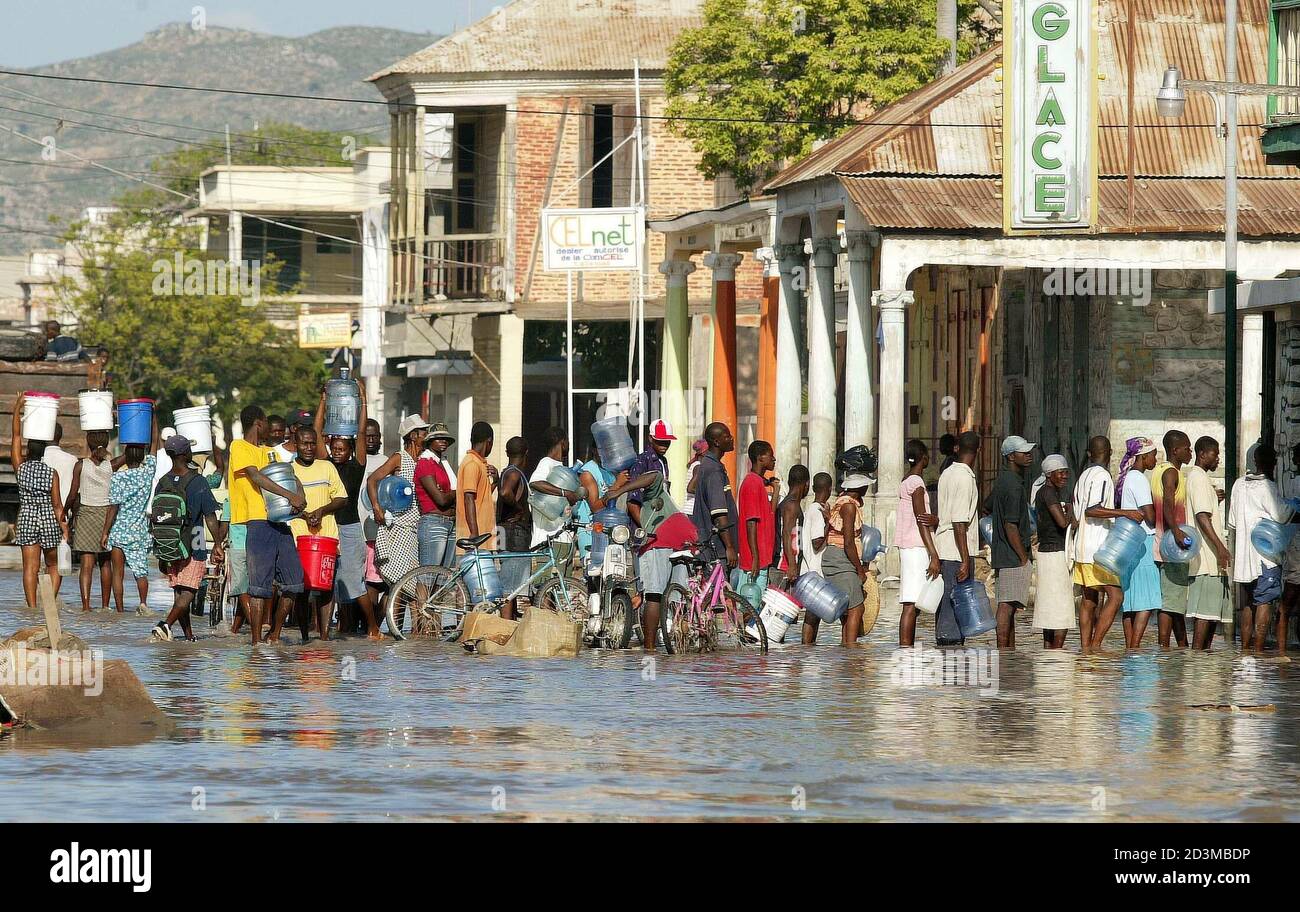 Haitian people wait in line for water outside a market in Gonaives, Haiti,  September 26, 2004. U.N. peacekeepers beefed up security in the Haitian  city of Gonaives where more than 1,000 people