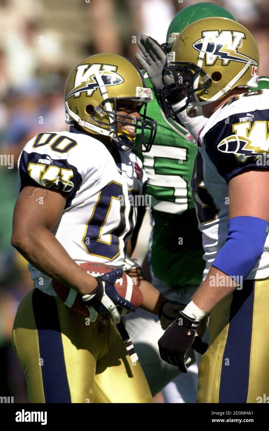 Winnipeg Blue Bombers' Brian Clark (L) and Ricky Bell (R) tackle BC Lions'  Geroy Simon during second quarter action from their CFL game in Vancouver  British Columbia October 4, 2003. REUTERS/Lyle Stafford