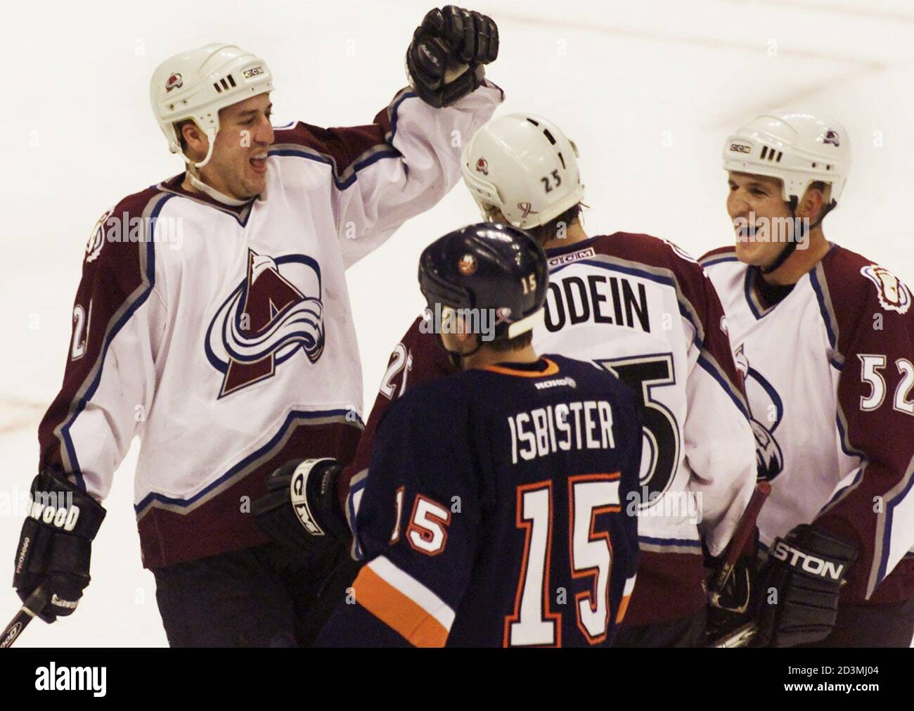 Colorado Avalanche left wing Shjon Podein (C) is congratulated after a goal against the New York Islanders by teammates winger Eric Messier (L) and defenseman Adam Foote during the first period in Denver, November 16, 2001. Islanders winger Brad Isbister (15) skates past the celebration. REUTERS/Gary C. Caskey  GCC/HK Stock Photo