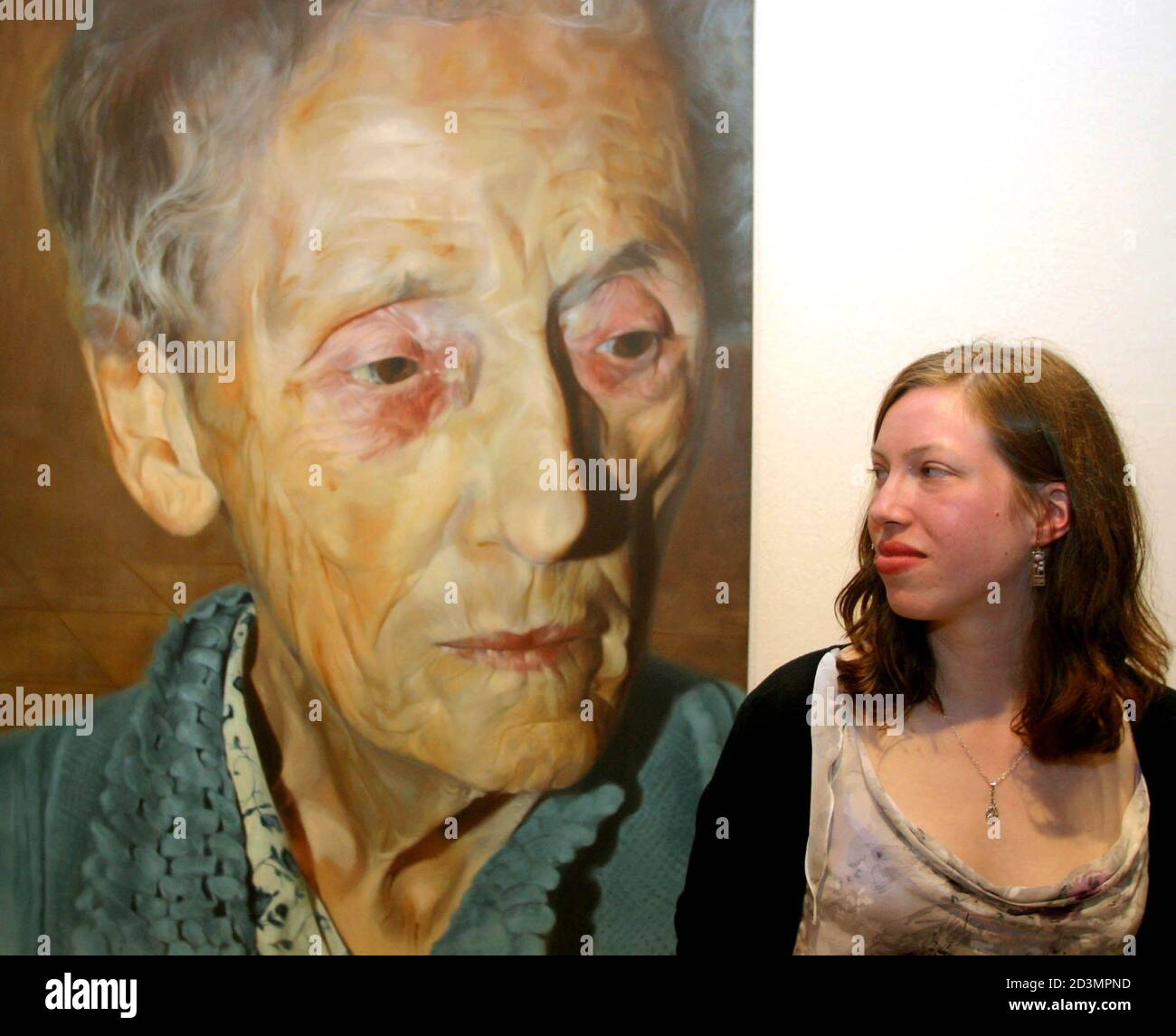 Charlotte Harris, winner of the 2003 BP Portrait Award, stands next to her untitled oil on canvas at the National Portrait Museum in London June 10, 2003. The 21-year old student was announced as the 25,000 pound sterling winner of the award on Tuesday night with her painting of her grandmother Doris Davis. REUTERS/Matt Dunham  MD/JDP Stock Photo