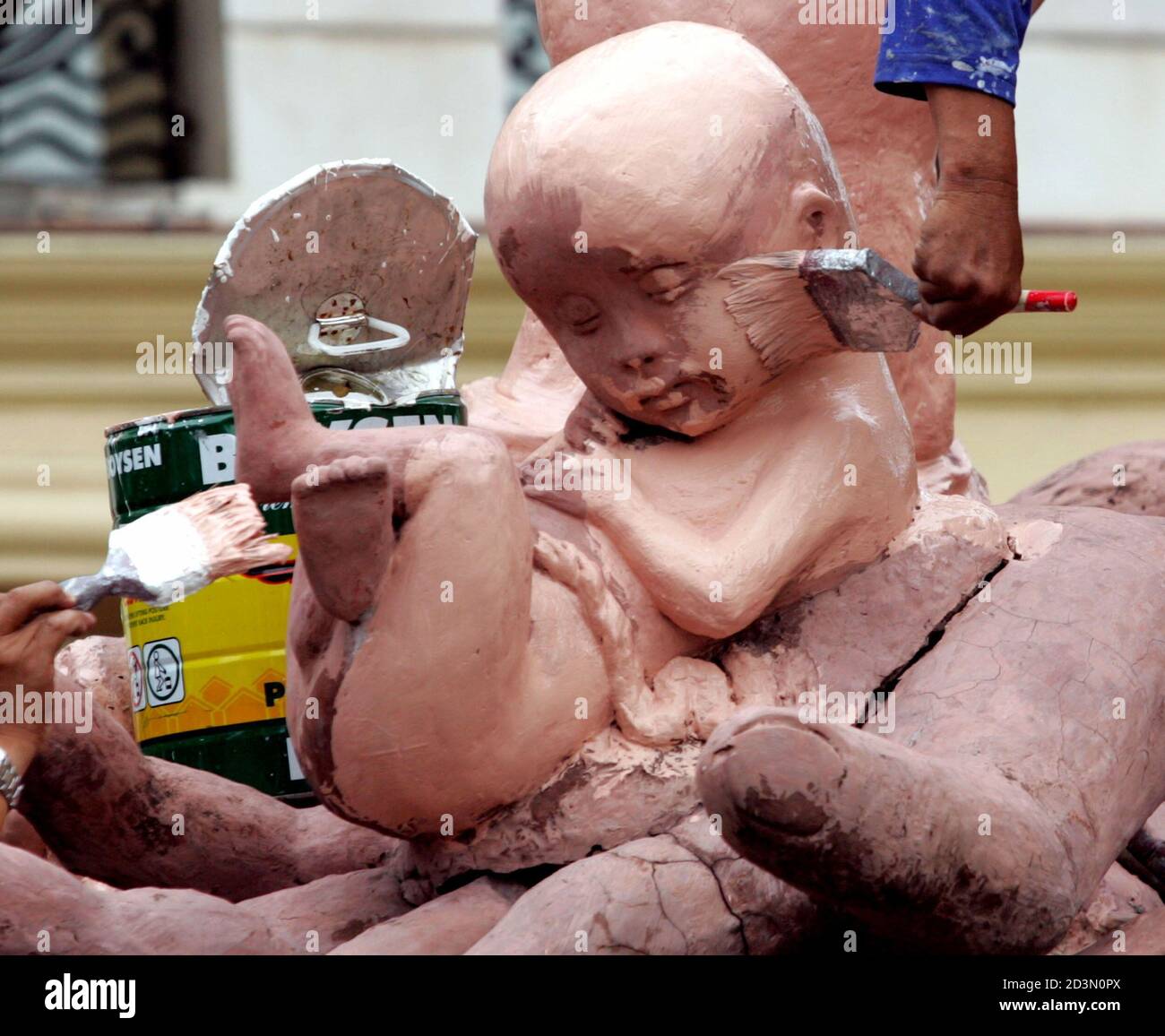 Filipino workers paint a monument for the unborn child, built outside a church in Manila, to oppose abortion in Asia's only predominantly Roman Catholic country April 4, 2005. Filipinos joined 1.1 billion other Roman Catholics around the world in mourning the death of Pope John Paul II, who had championed the anti-abortion cause. The Pope died on Saturday night in the Vatican City. REUTERS/Erik de Castro  edc/JK Stock Photo