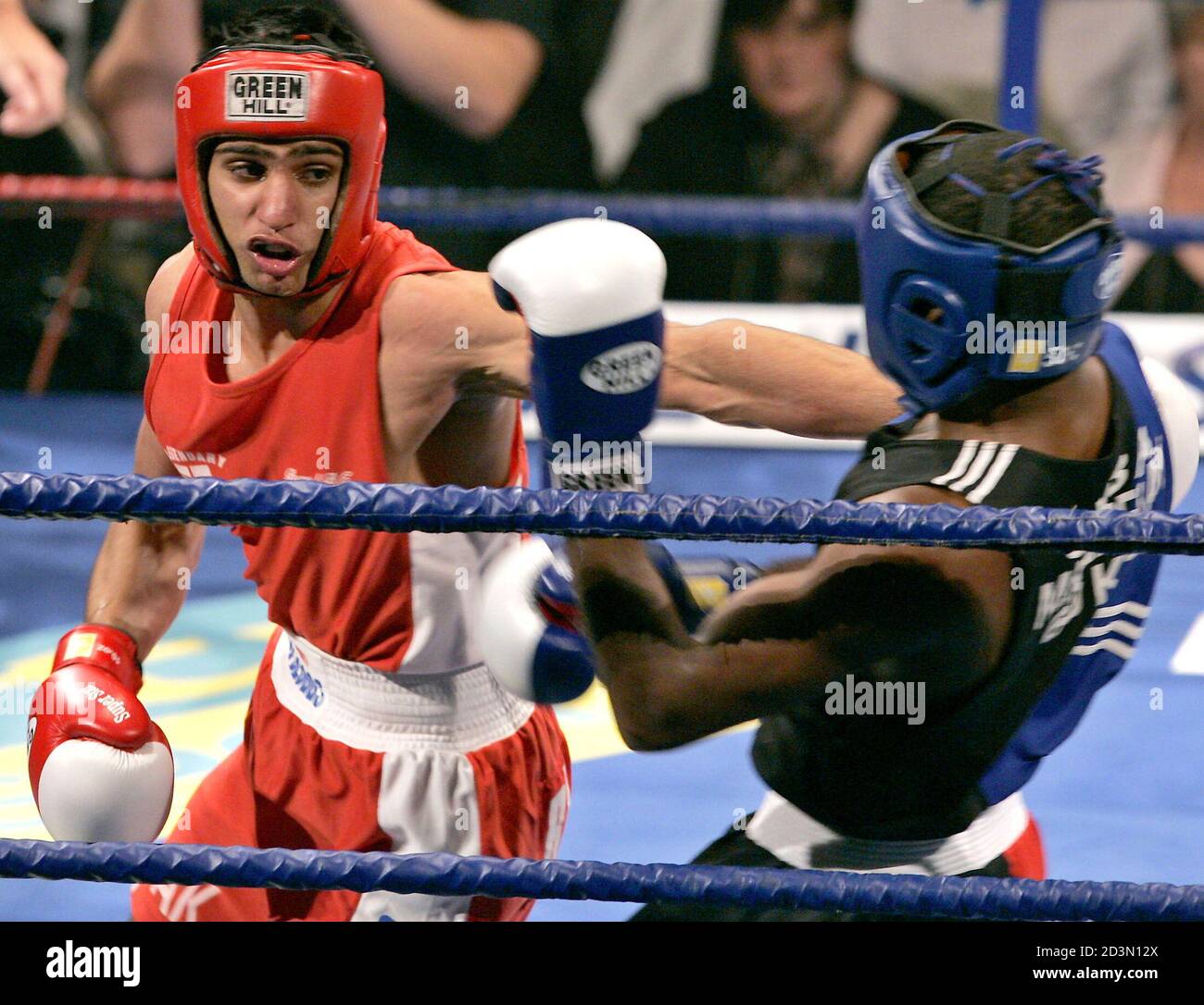 Cuban Mario Kindelan (R) takes a punch from Amir Khan (L)during their fight  at the Reebok stadium in Bolton, May 14, 2005. The fight is a rematch of  the Athens 2004 Olympic