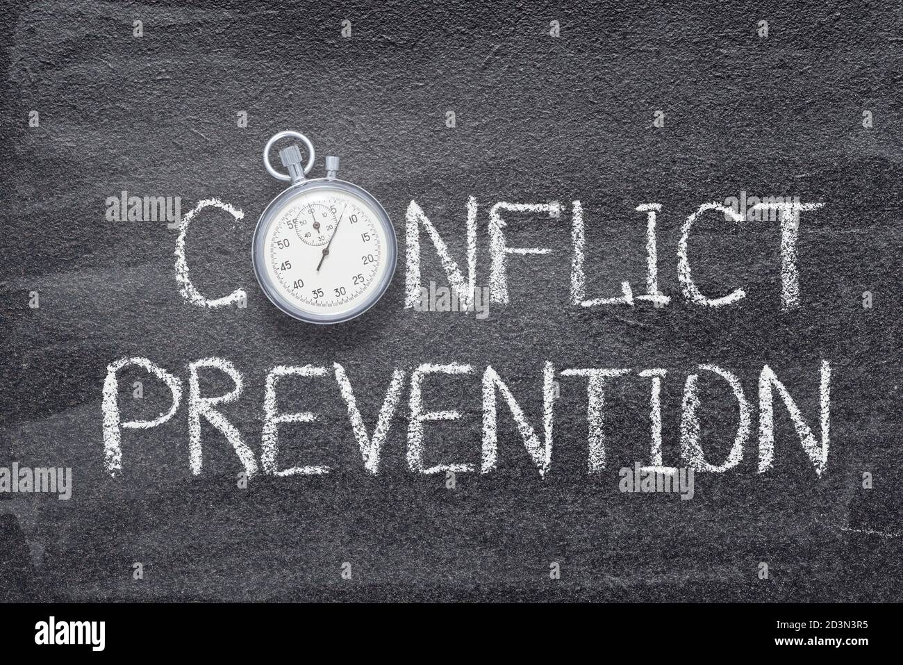 conflict prevention phrase written on chalkboard with vintage precise stopwatch Stock Photo