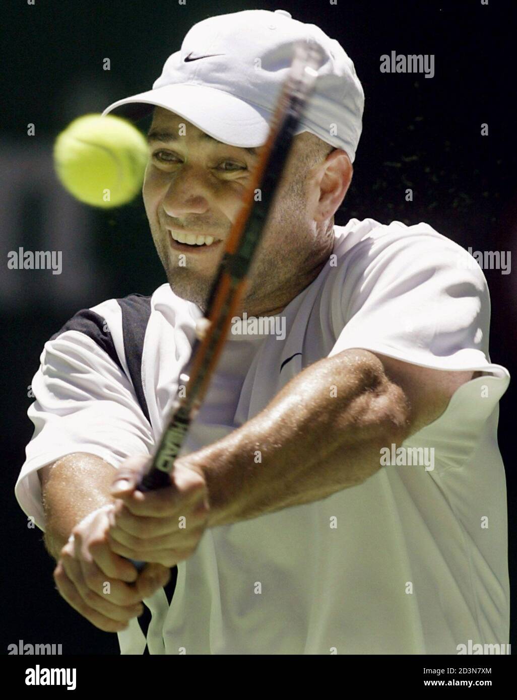 Andre Agassi of the United States hits a backhand to Sebastien Grosjean of  France during their quarterfinal match at the Australian Open in Melbourne  January 21, 2003. Agassi defeated Grosjean 6-3 6-3