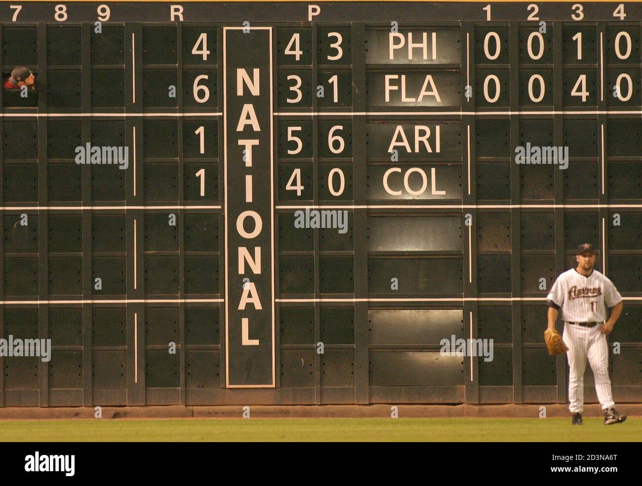 The scoreboard operator (upper left) yells at Houston Astros left fielder Lance Berkman to let him know the Reds had taken the lead over the Cubs in the National League Central game, during the fourth inning September 25, 2003 in Houston. The Astros, playing the Milwaukee Brewers, trailed the Cubs by one game going into tonight's play. REUTERS/F. Carter Smith  FCS/HB Stock Photo
