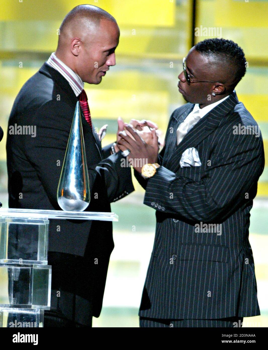 actor-dwayne-the-rock-johnson-l-receives-from-rapper-p-diddy-the-action-hero-of-the-year-award-at-the-8th-annual-gq-men-of-the-year-awards-in-new-york-on-october-21-2003-reutersalbert-ferreira-af-2D3NAAA.jpg