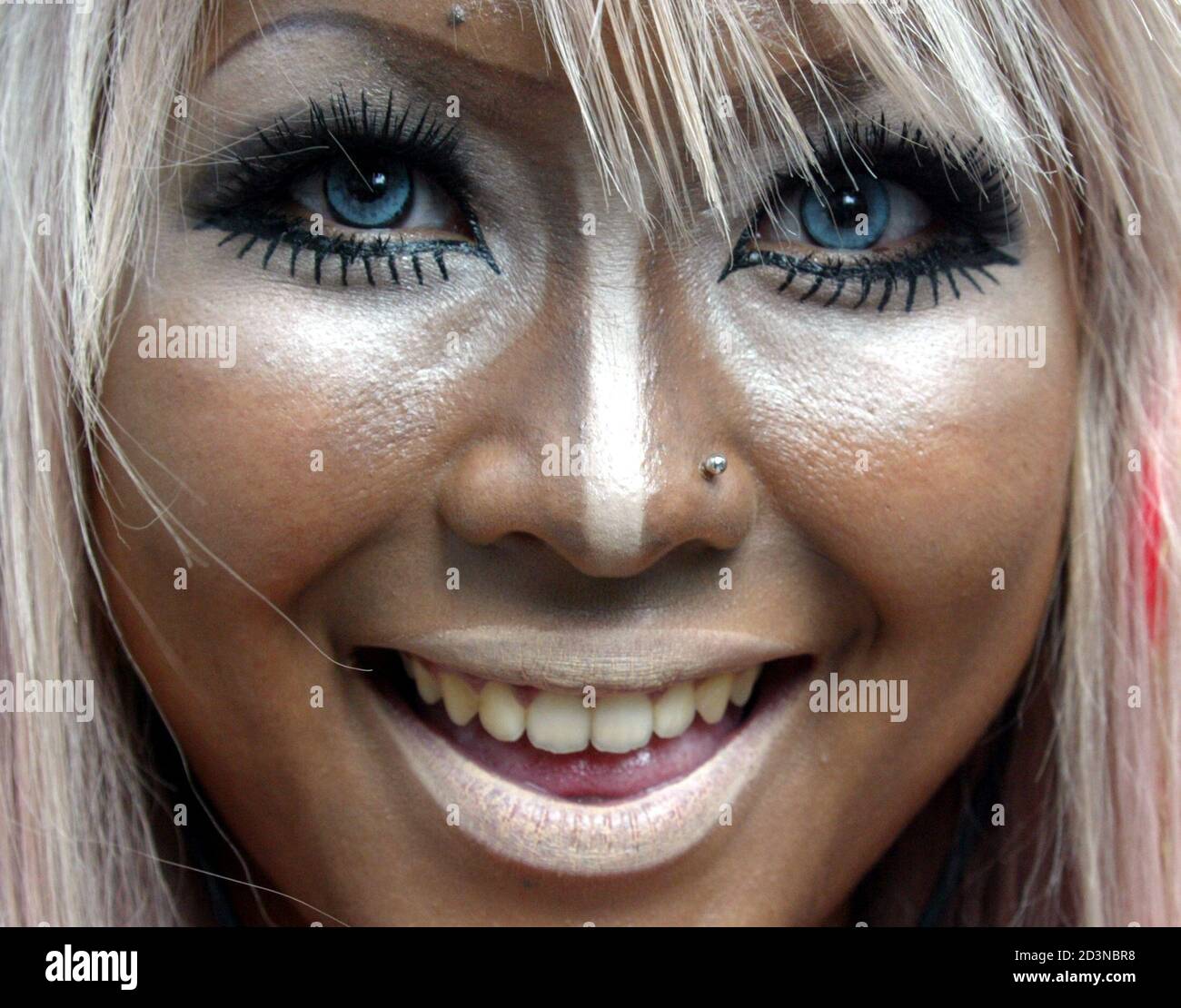 A fashionable "Shibuya girl" smiles in her blue contact lenses in Tokyo's  Shibuya district, popular among Japan's young people, May 4, 2004. "I'm  sweating from the moment I put on this makeup,"