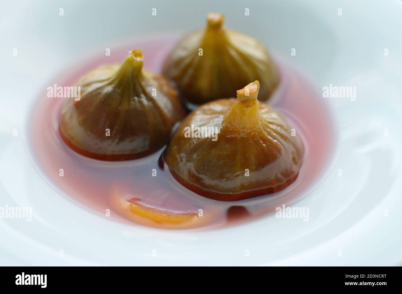 Closeup shot of three figs in syrup dessert Stock Photo