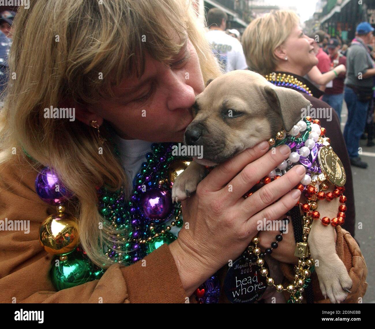 Karen Spear of West Palm Beach, Florida kisses her dog Grazer, a seven week-old Pitt Bull, on Bourbon Street in New Orleans during Mardi Gras, Febraury 7, 2005. It is Spear's third trip to Mardi Gras. The Carnival season culminates on Fat Tuesday, or Mardi Gras, on February 8. REUTERS/David Rae Morris  drm/GN Stock Photo