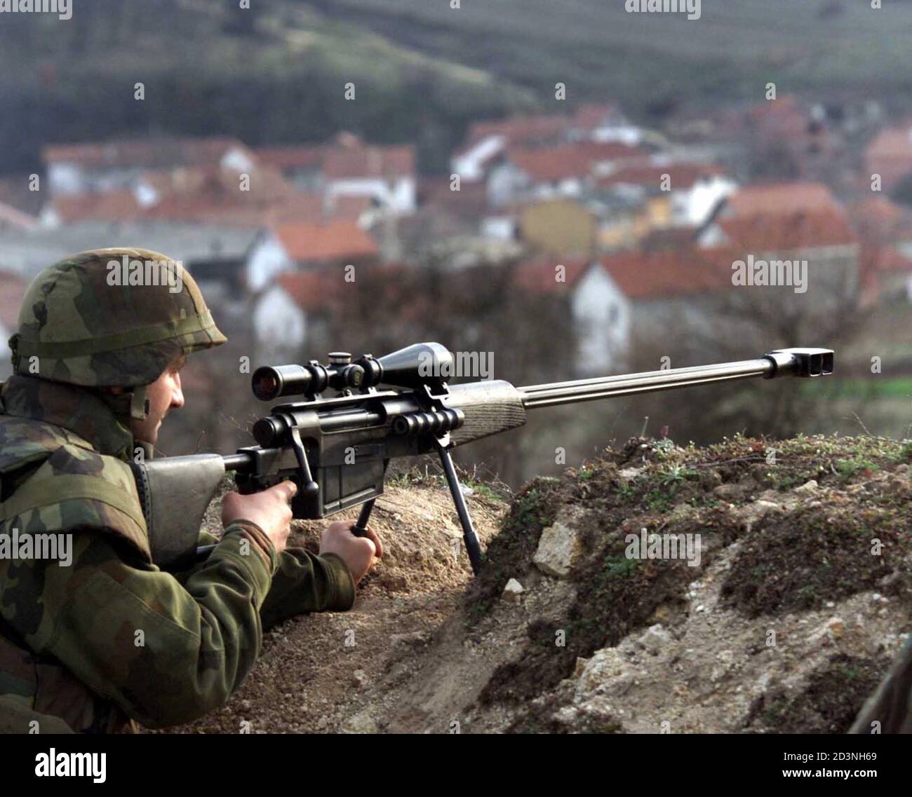 A Yugoslav army soldier sits in a trench manning a Black Arrow sniper rifle  near the Southern Serbian village of Rajince outside the 5km buffer zone  with Kosovo March 13, 2001. A