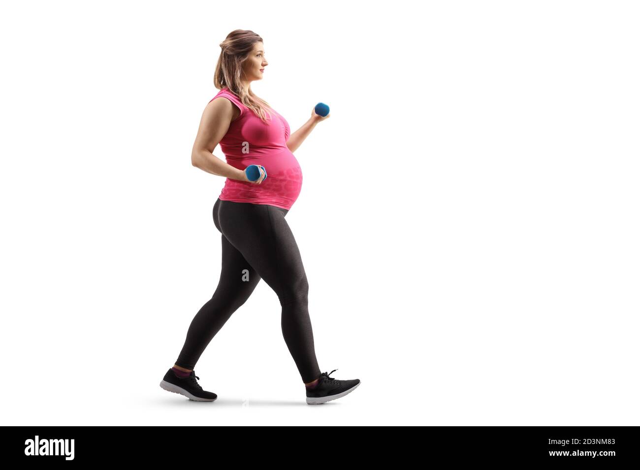 Full length profile shot of a pregnant woman walking and exercising with dumbbells isolated on white background Stock Photo