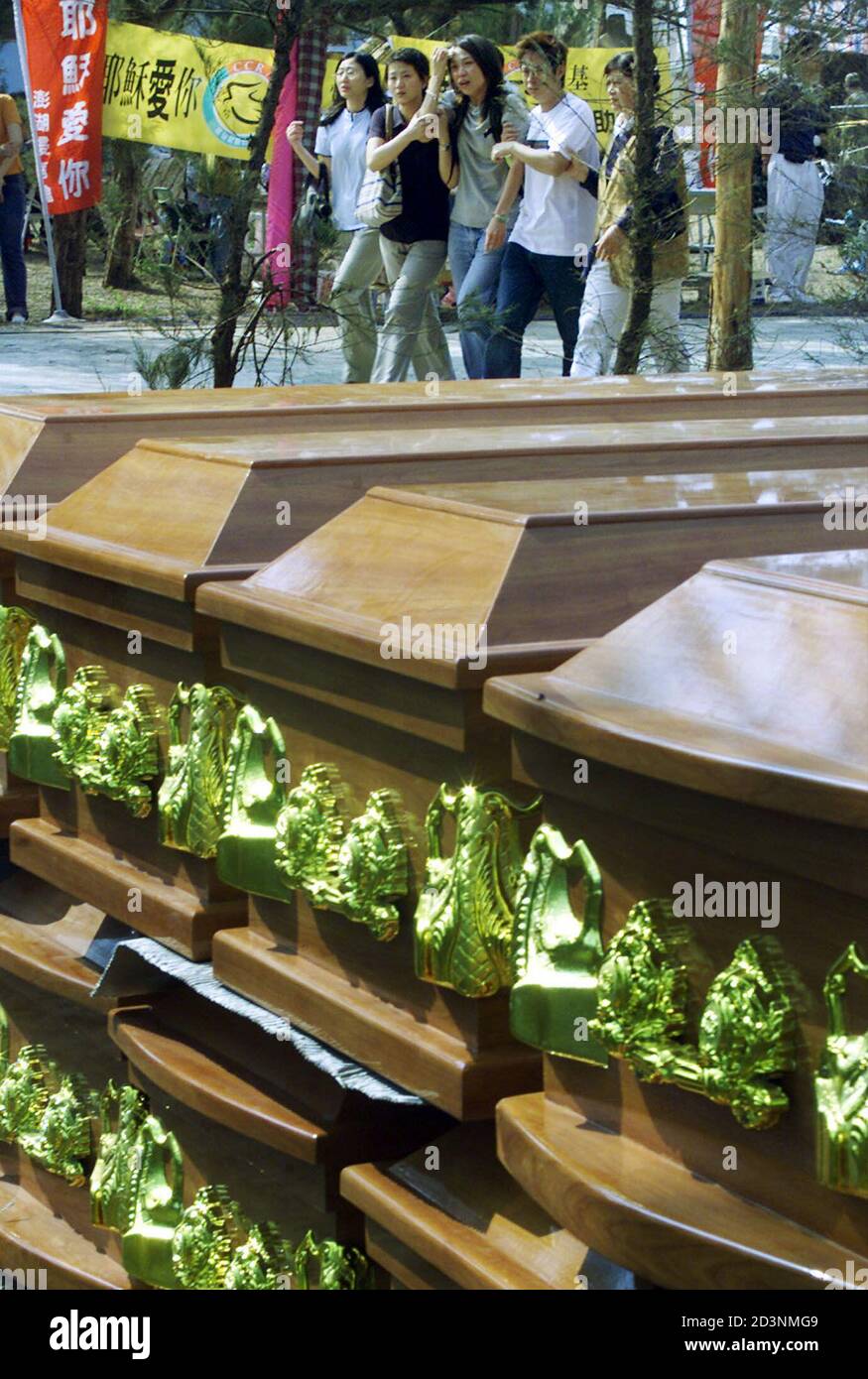 Relatives of passengers aboard China Airlines flight CI 611 that crashed into the ocean en route to Hong Kong from Taiwan cry beside stacks of coffins at a stadium on the island of Penghu May 27, 2002. Taiwan officials were investigating on Sunday why a China Airlines plane broke into four pieces and plunged into the sea, killing all 225 people on board, in Asia's third major air crash in six weeks. REUTERS/Kenny Wu  KW Stock Photo