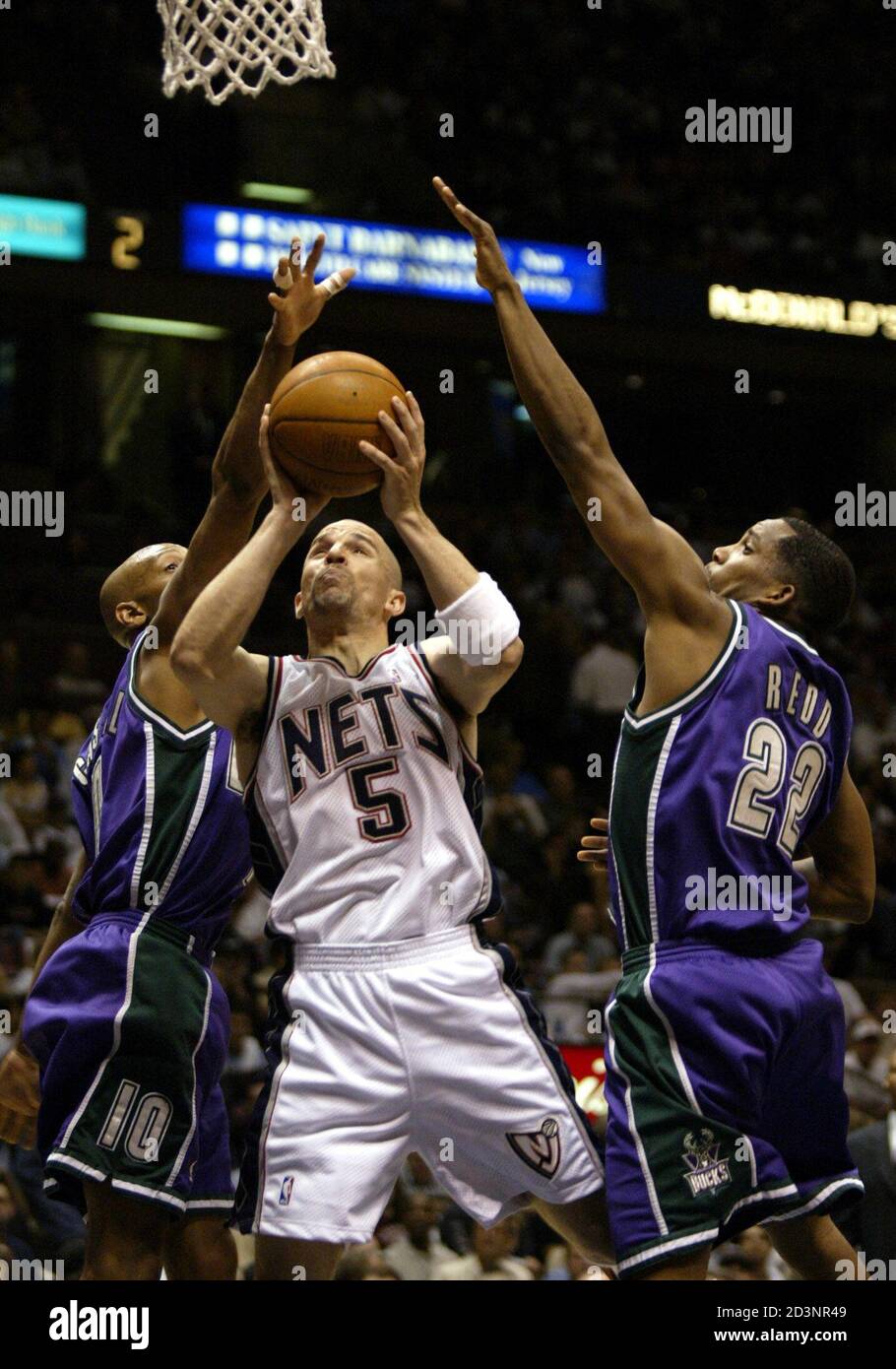 New Jersey Nets guard Jason Kidd (C) drives for a layup between Milwaukee  Bucks guard Sam Cassell (L) and Michael Redd in the second quarter of their  NBA playoff game in East