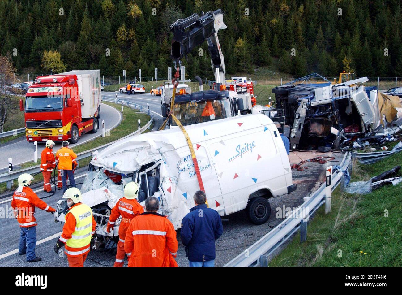 A mini bus in which the driver died, is lifted from the accident scene  where the debris of a British truck can be seen behind (R) at Pian San  Giacomo near the