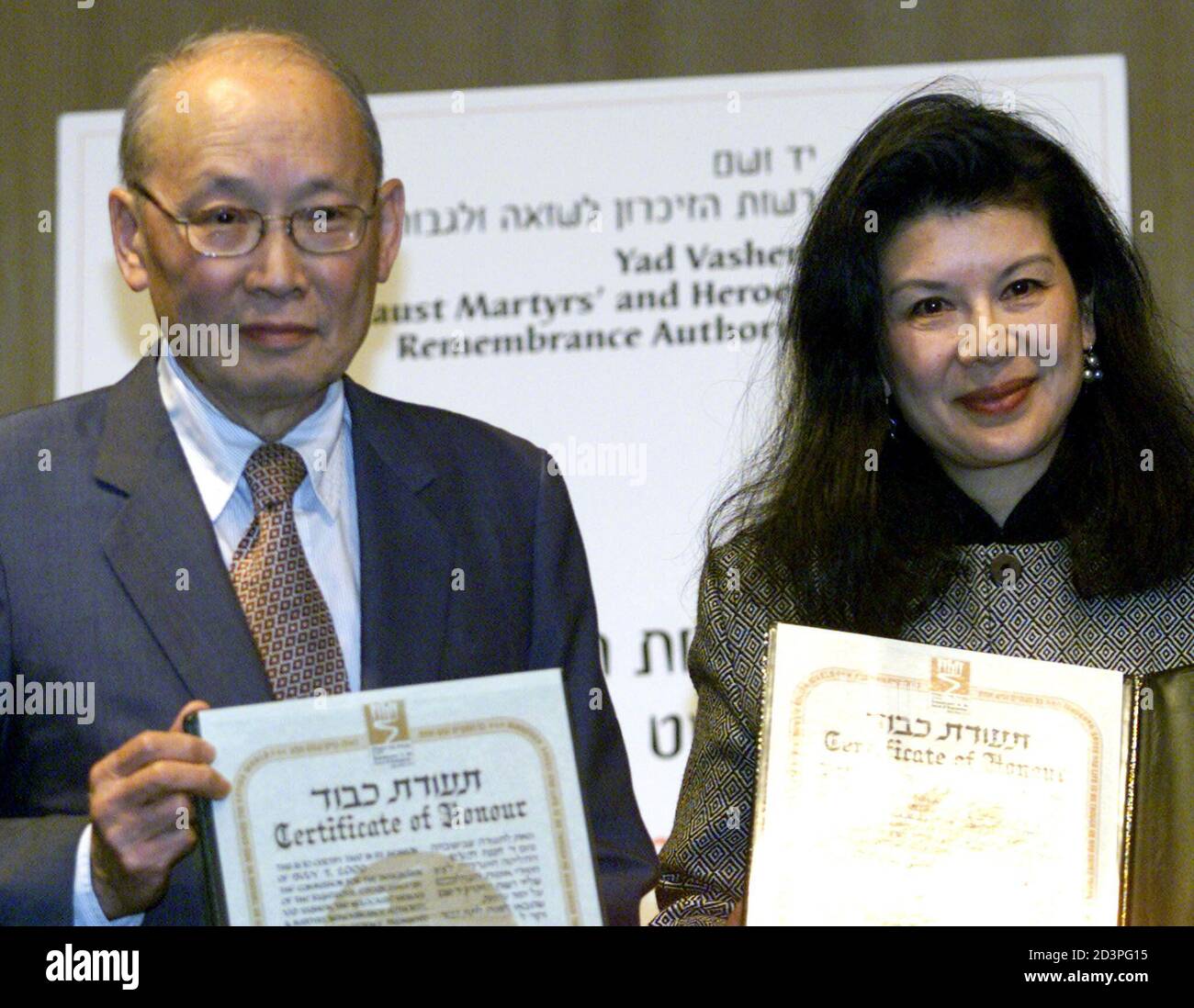 The late Chinese Consul-General in Vienna during 1938-40, Ho Feng Shan's, son Monto and daughter Manli display their 'Righteous Among The Nations' awards in the Yad Vashem Holocaust Memorial auditorium in Jerusalem January 23, 2001. Monto, from Pittsburgh, PA and Taiwan, and Manli, from Maine and San Francisco, received the award on behalf of their father who issued hundreds, if not thousands, of exit visas to Jews living in Austria which was part of Nazi Germany. Shan disregarded orders from his superiors and continuing issuing visas to Shanghai to all Jews who requested them, thus saving man Stock Photo