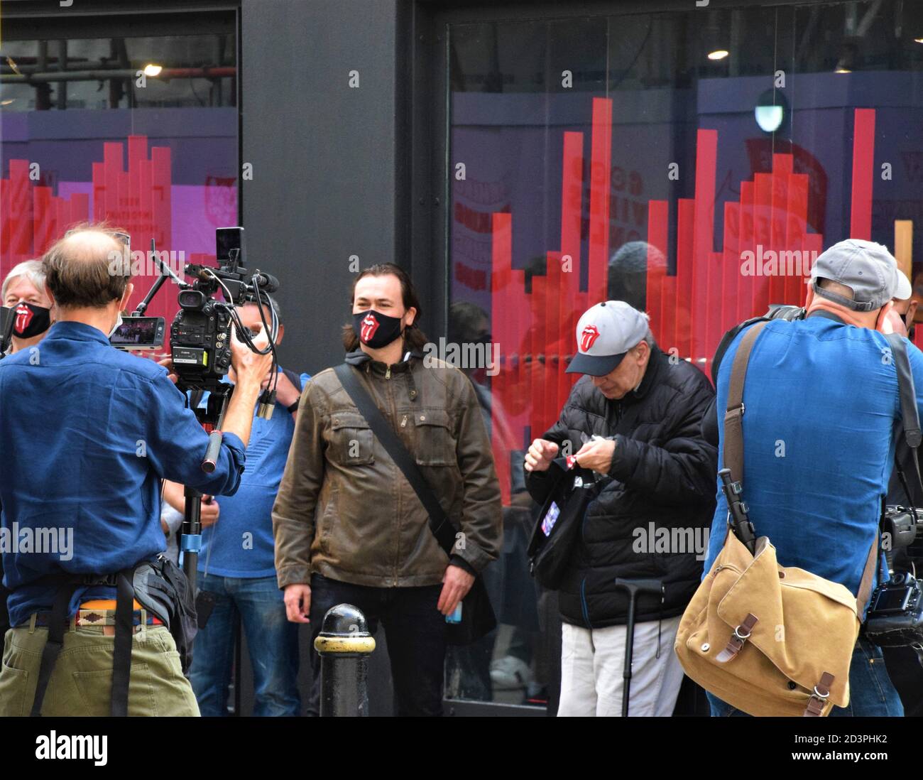 Fans wearing face masks on opening day of the world's first Rolling Stones store on Carnaby Street, London Stock Photo