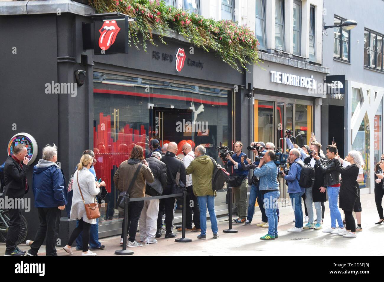 People queuing on opening day of the world's first Rolling Stones store on Carnaby Street, London Stock Photo