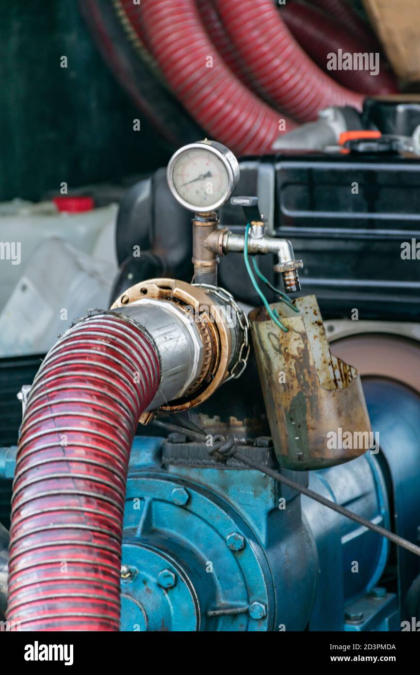 Fuel hose connected to a motorized pump with pressure gauge Stock Photo