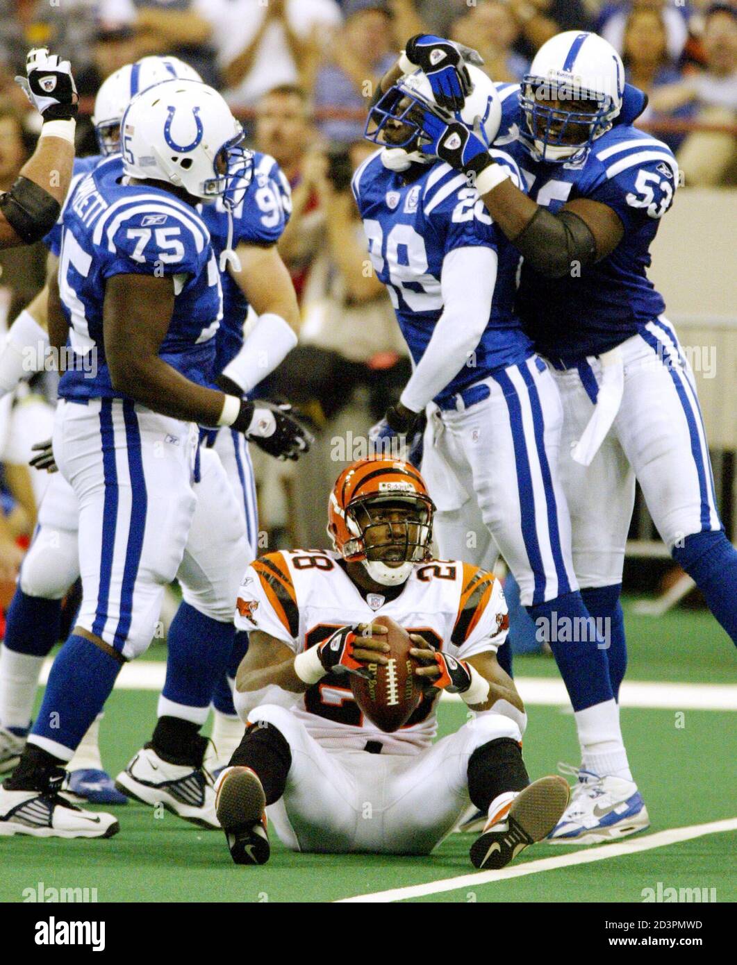 Indianapolis Colts' players Larry Tripplett (75), Idrees Bashir (28) and Marcus Washington (53) celebrate after bringing down Cincinnati Bengals' running back Corey Dillon (with ball) for a loss, October 6, 2002 at the RCA Dome in Indianapolis during first quarter NFL play. REUTERS/Brent Smith  BS/HB Stock Photo