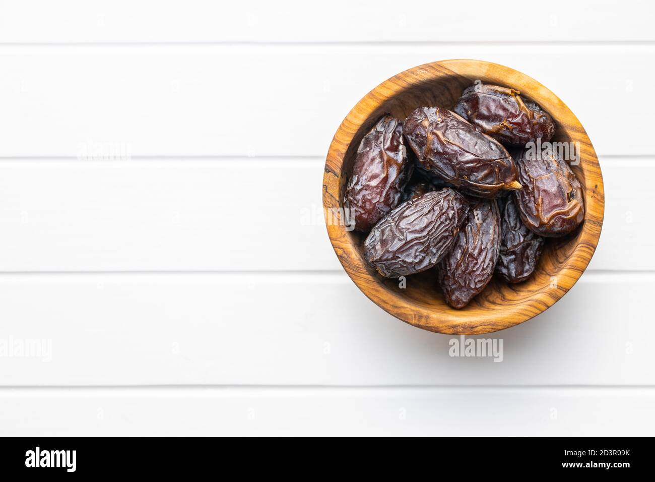 Dried dates fruit in wooden bowl. Top view Stock Photo - Alamy