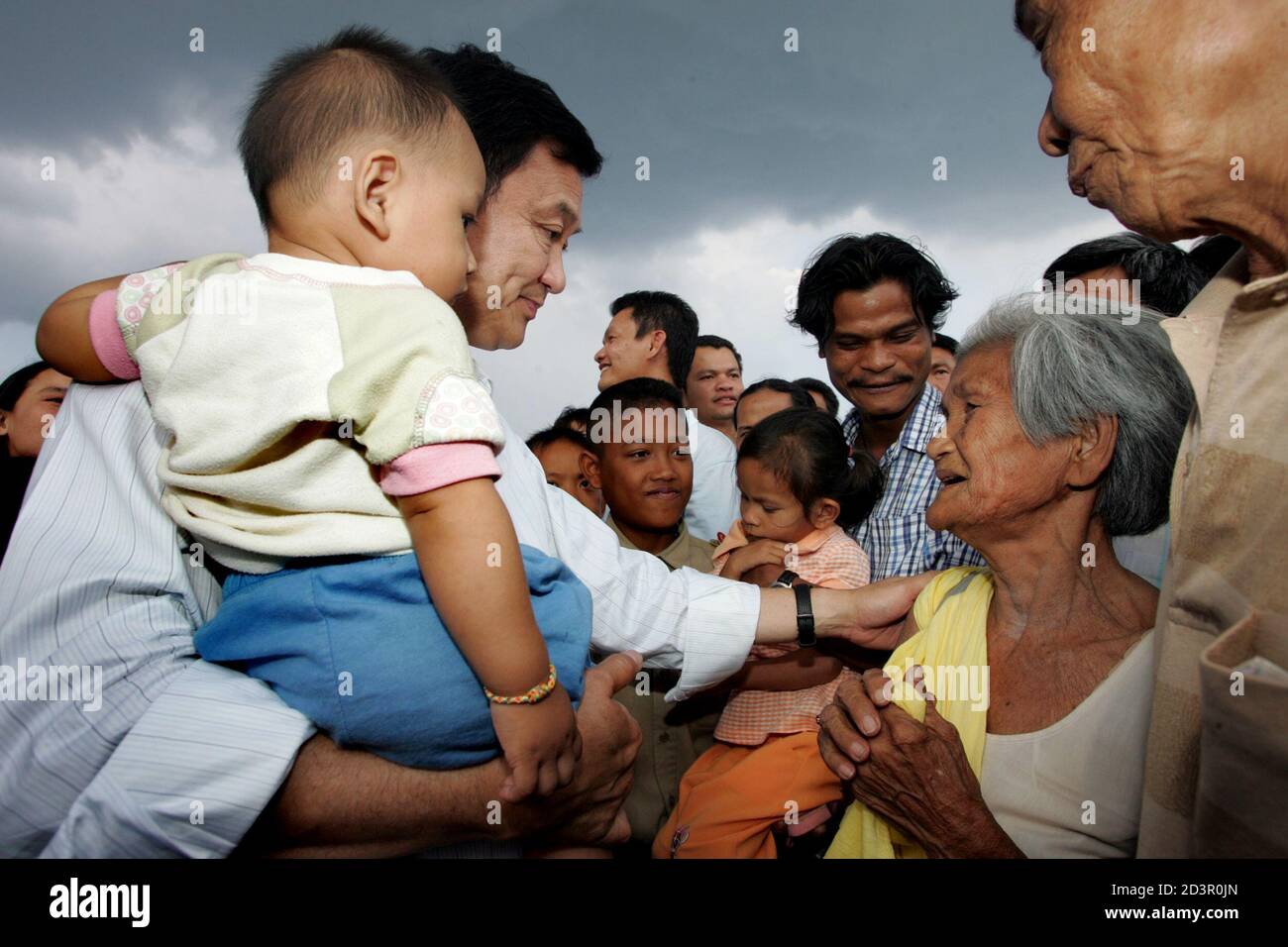 Thai Prime Minister Thaksin Shinawatra carries a child as he meets villagers in Yala province, 1,200 km (750 miles) south of Bangkok, on February 16, 2005. Thaksin arrived in the largely Muslim south on Wednesday with a stern message for villagers tempted to help separatist militants. REUTERS/Sukree Sukplang  SS/SA Stock Photo