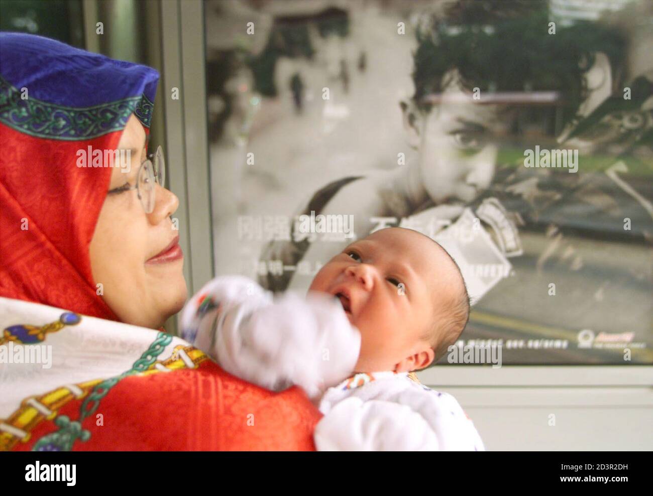 Five Day Old Malay Boy Mohammed Armin A Third Child In His Family Rests On His Mother S Shoulder In Front Of A Singapore Armed Forces Mandarin Advertistment At A Bus Stop In Singapore September