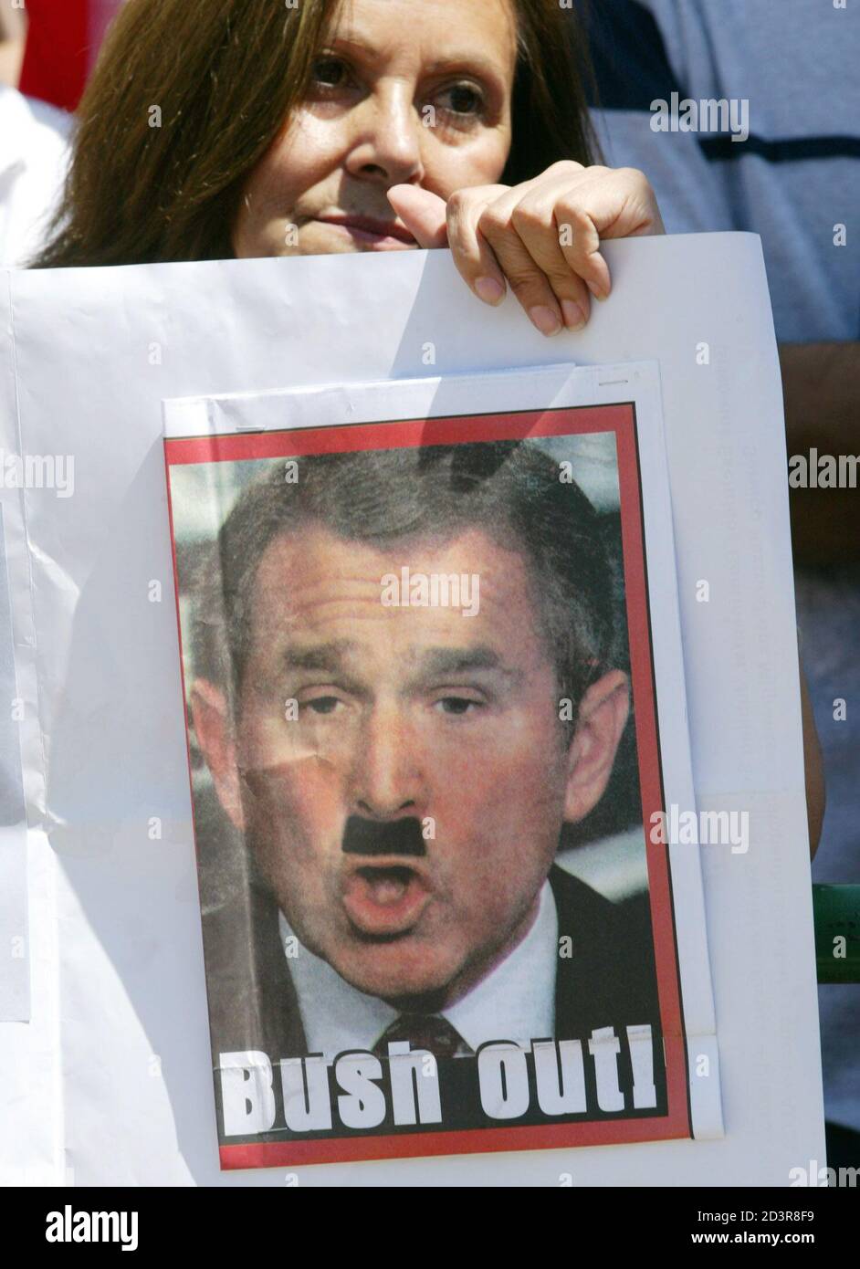 a-woman-holds-a-picture-of-us-president-george-w-bush-with-an-adolf-hitler-moustache-during-a-peace-really-outside-the-presidential-palace-la-moneda-in-santiago-february-15-2003-millions-of-people-took-to-the-streets-of-towns-and-cities-around-the-globe-on-saturday-to-demonstrate-against-a-looming-us-led-war-on-iraq-reutersclaudia-daut-cd-2D3R8F9.jpg