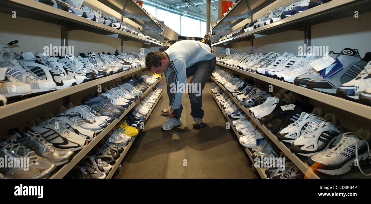 A man tries on sport shoes at an Adidas factory outlet in Herzogenaurach  March 10, 2004. The world's second-biggest sports-goods maker, Adidas-Salomon  AG, said on Wednesday orders at the end of 2003