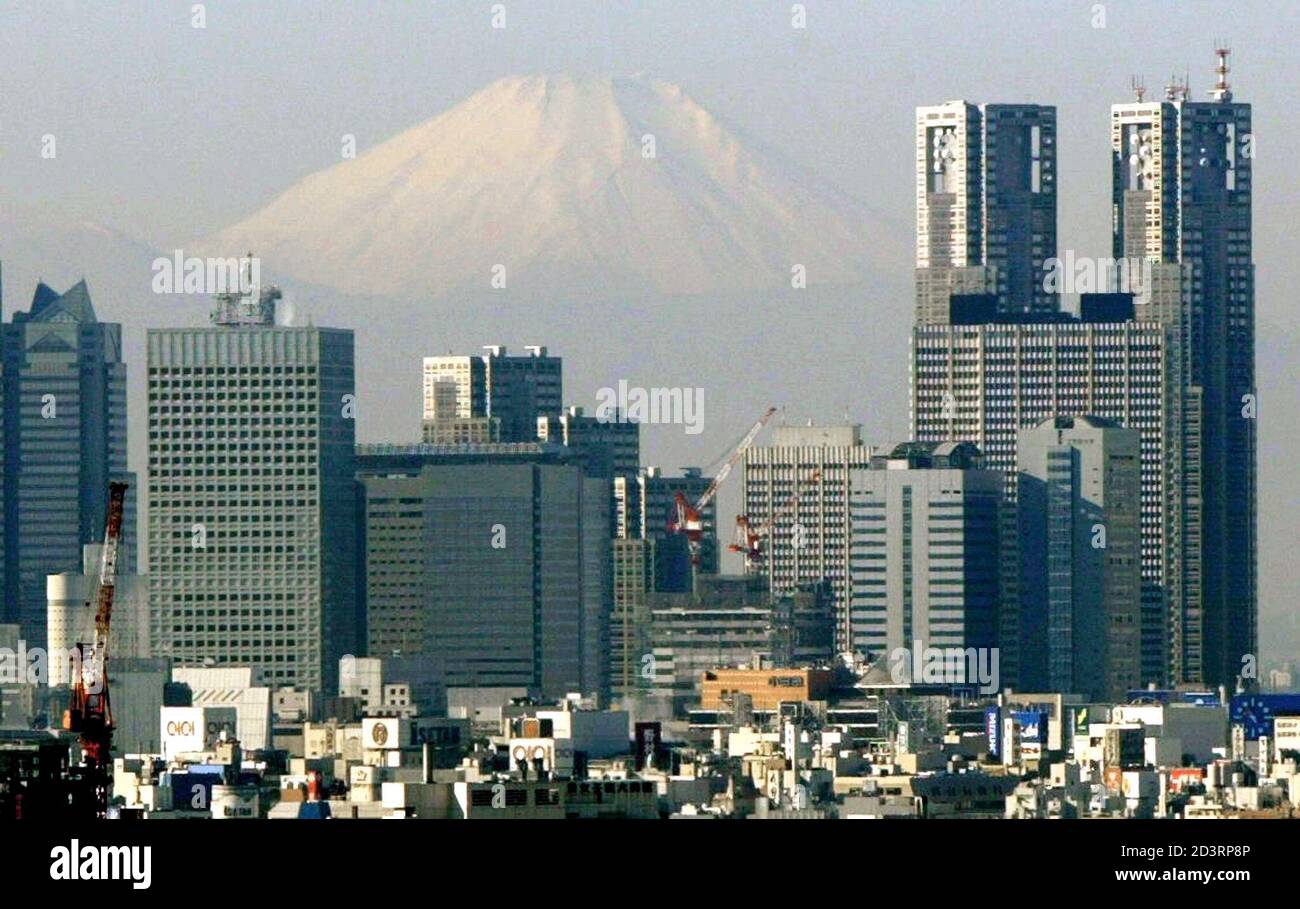 Mt. Fuji looms over skyscrapers in Tokyo's Shinjuku district on December 14, 2002. At 3,776 metres (12,388 feet), Japan's highest peak is only about 100 km (62 miles) southwest of the capital. REUTERS/Kimimasa Mayama  KM/JD Stock Photo