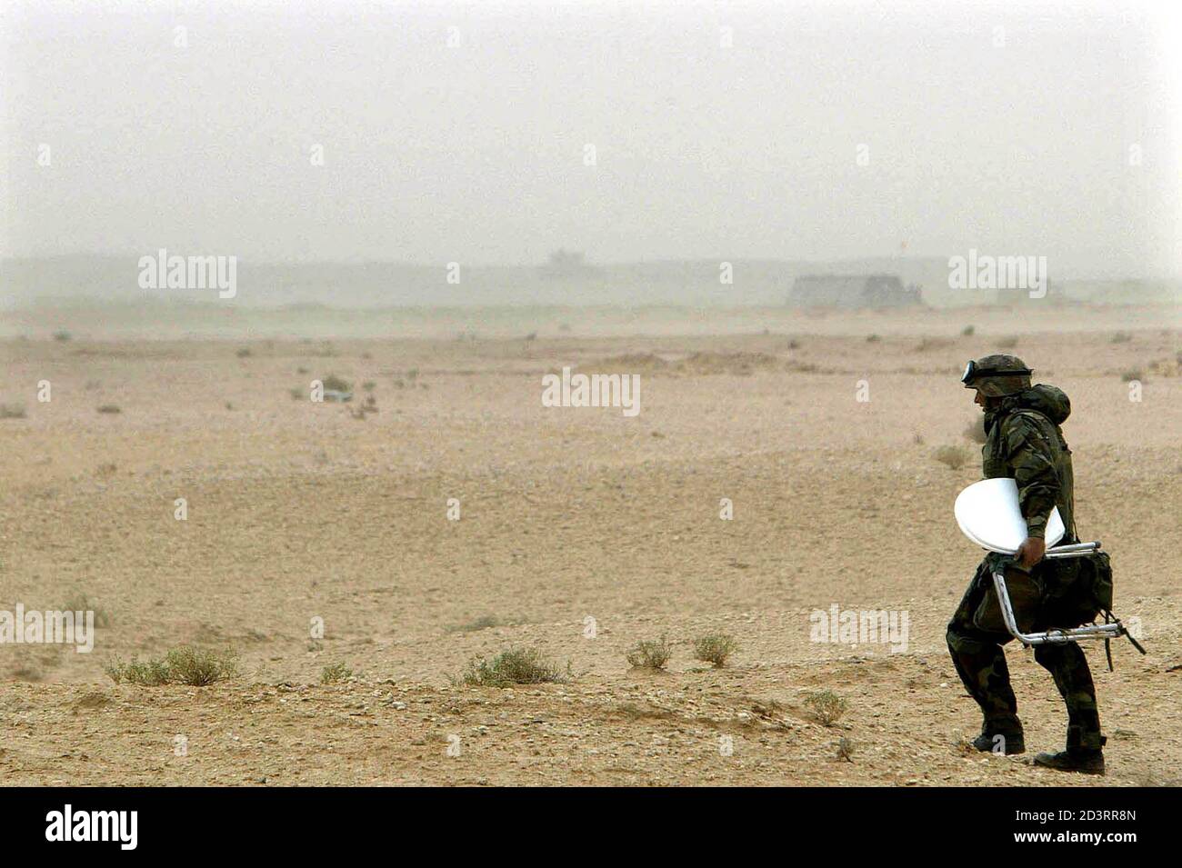 A U.S. Army engineer carries his selfmade mobile toilette seat as he searches a private place out in the desert in the south of the city of Najaf in central Iraq, March 23, 2003. The United States cast doubt on Monday on the fate of Saddam Hussein despite a defiant televised speech by the Iraqi President hailing resistance to U.S. and British invasion forces. REUTERS/Kai Pfaffenbach  KP/AA Stock Photo