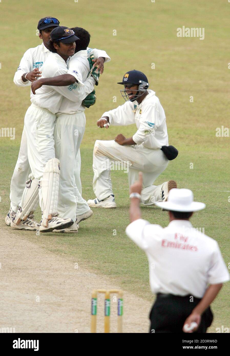 Sri Lankan spinner Muttiah Muralitharan (3rd from left) is congratulated by teammates as umpire Aleem Dar raises his finger to rule England opener Marcus Trescothick out during England's first innings of the second test match against Sri Lanka in Kandy on December, 11, 2003. REUTERS/Anuruddha Lokuhapuarachchi  AL/TW Stock Photo