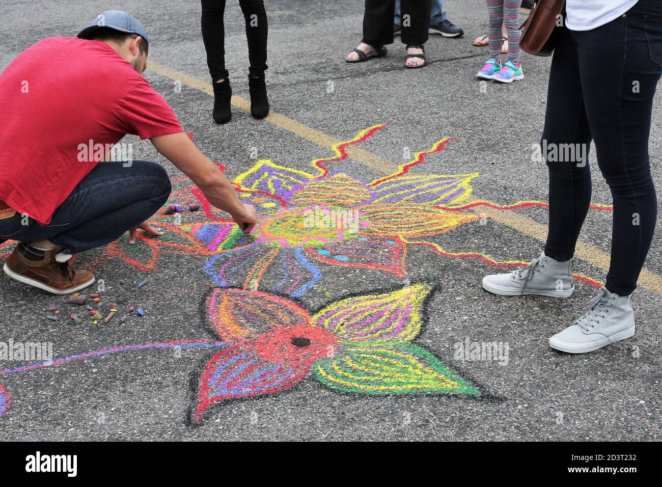 A man drawing flowers at the Chalk Walk Arts Festival in Minneapolis