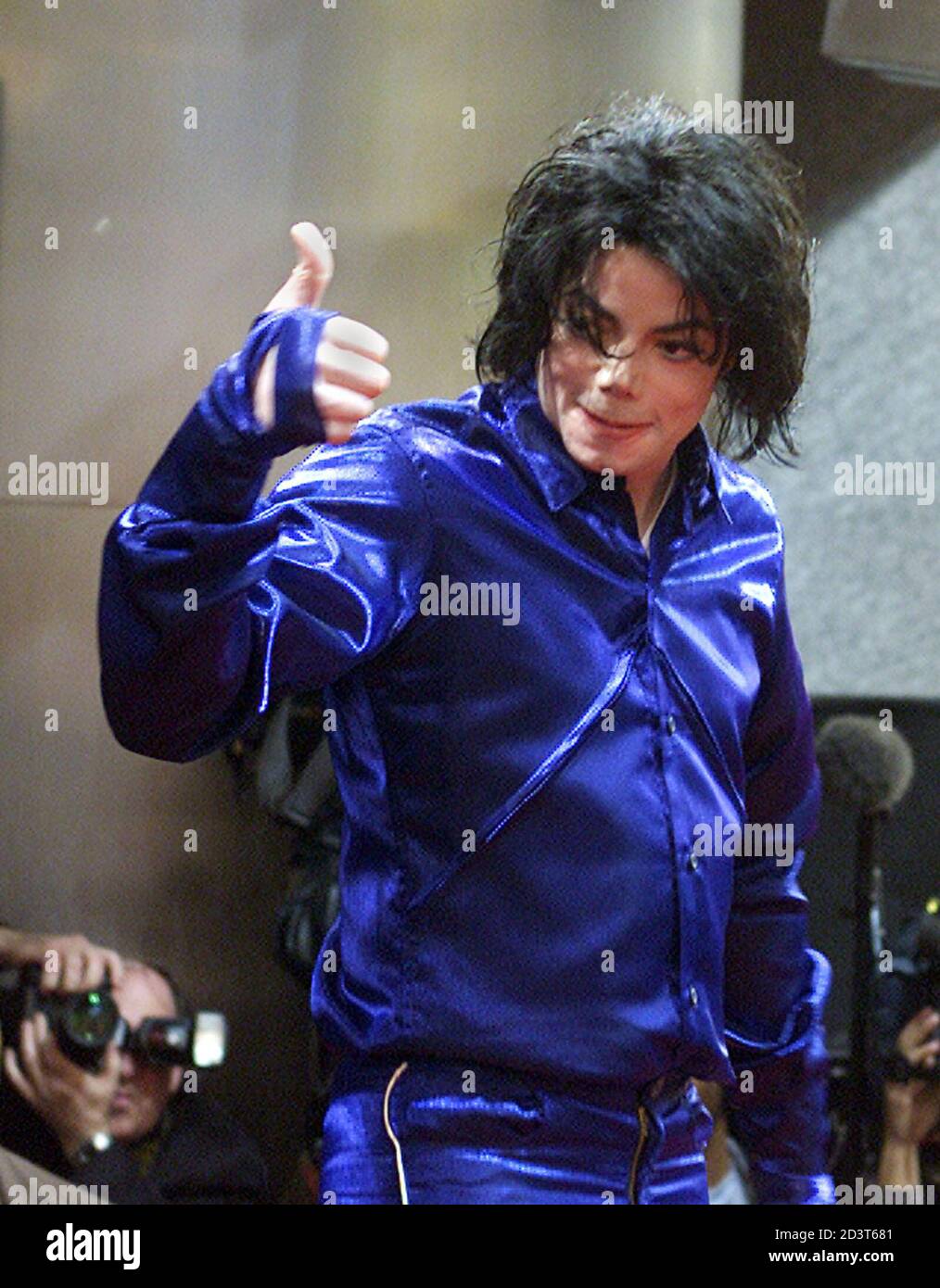 Entertainer Michael Jackson gives a thumbs up to the crowd gathered for his  appearance in Times Square in New York on November 7, 2001. Jackson made  his first ever in-store appearance to