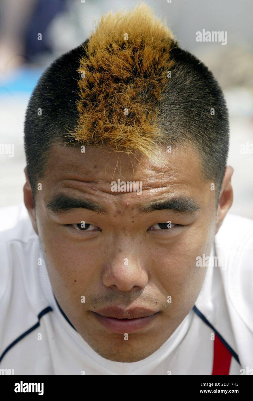 A soccer fan with a hair style similar to one worn by England's David  Beckham waits in front of World Cup Stadium in Taegu June 9, 2002, having  arrived two days before
