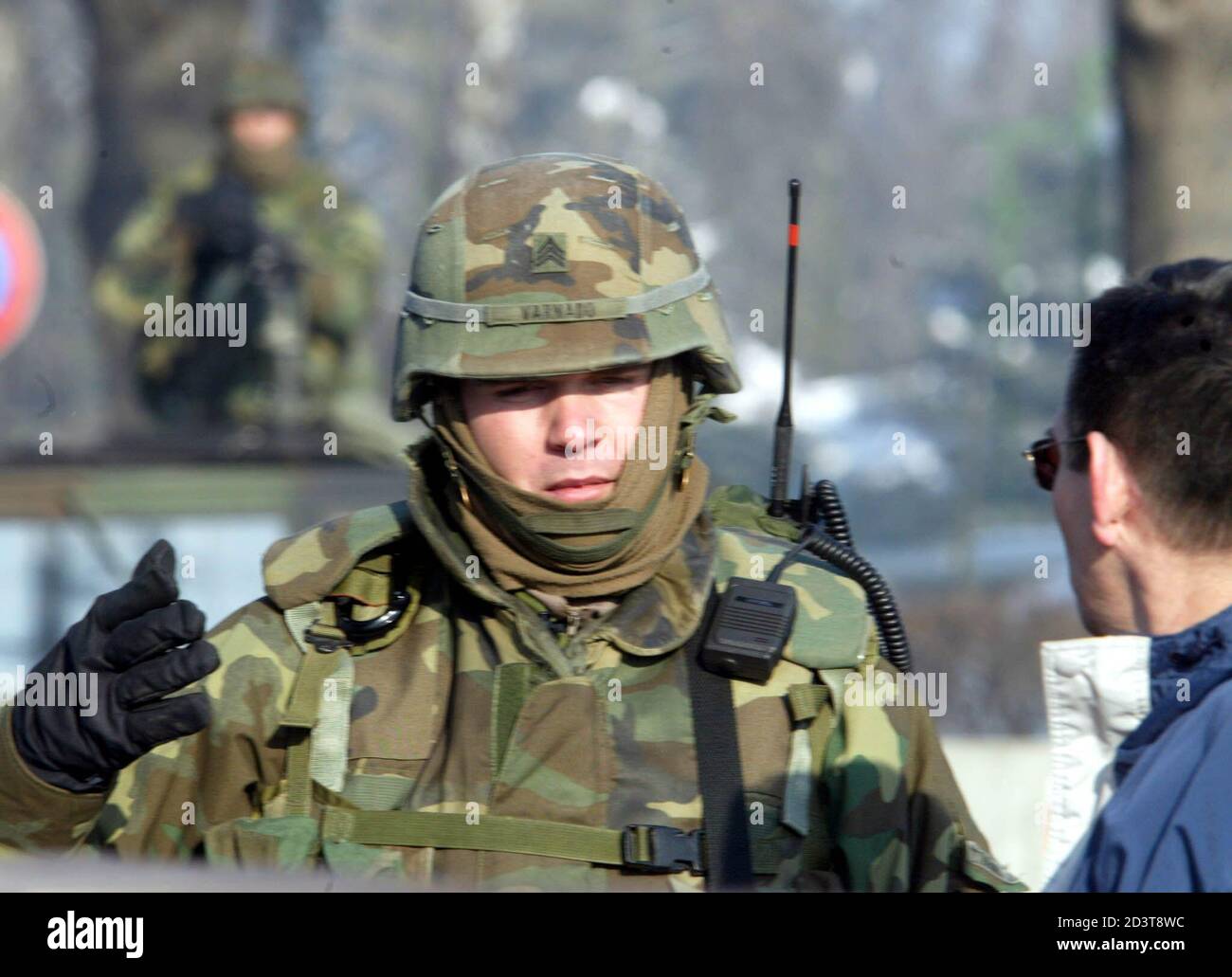 An American soldier talks to a Hungarian man as he guards a military  airbase at Taszar in southern Hungary on January 16, 2003. The U.S. is due  to begin training up to