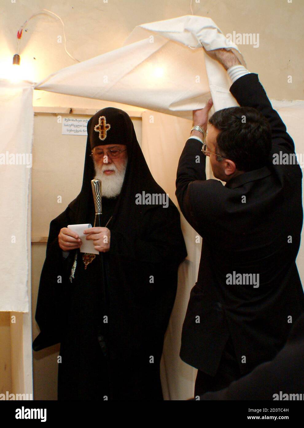An election official helps Patriarch Ilia II of Georgia to leave a polling booth in Tbilisi March 28, 2004. Georgians voting in a parliamentary election on Sunday were poised to hand President Mikhail Saakashvili's allies a big victory, but tensions in a wayward province threatend to cast a shadow over the poll. Irakli Gedenidze/REUTERS REUTERS  GD/FMS Stock Photo