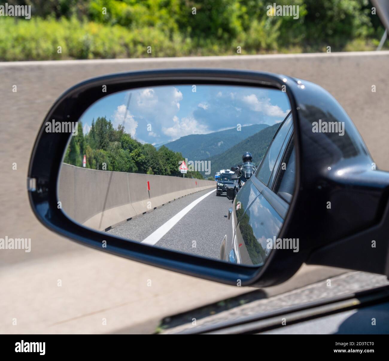 Traffic jam on European highway - lots of cars standing in the queue seen from the rearview mirror Stock Photo
