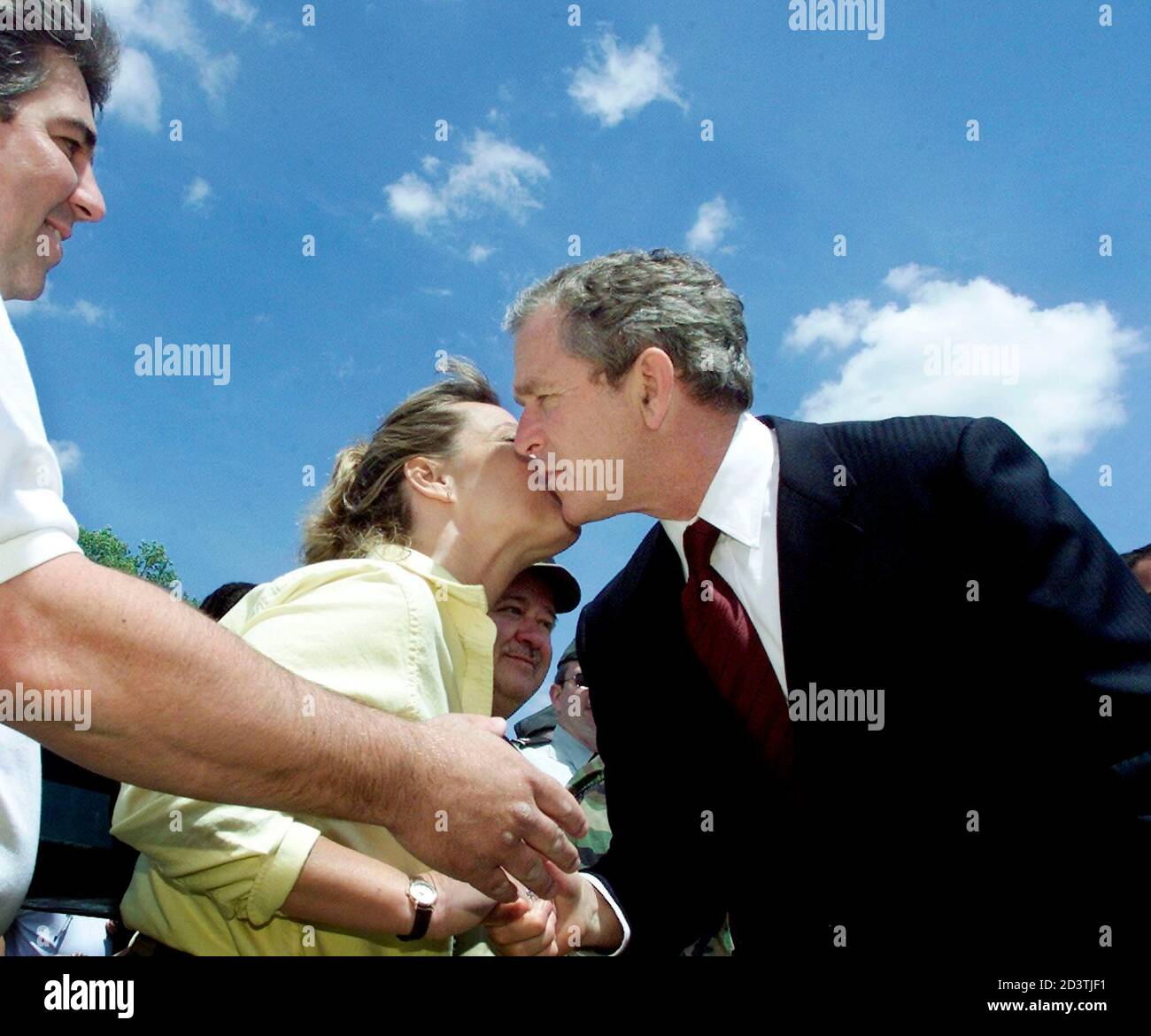 U.S. President George W. Bush receives a kiss while shaking hands on  departure along the ropeline next to Air Force One at Bradley International  Airport in Windsor Locks, Connecticut, May 21, 2001.