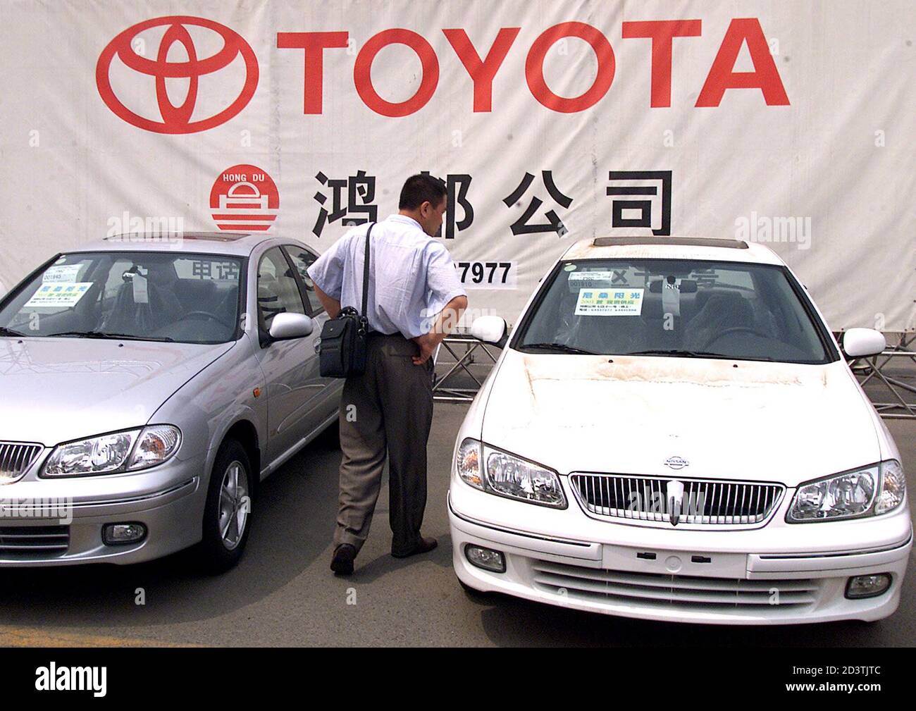 A Chinese man looks at a Japanese-made Toyota car at an outdoor auto market  in Beijing June 22, 2001. Japan and China dug in their heels in an  escalating trade war between