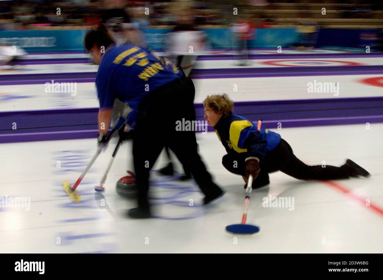 Swedish skip Elisabet Gustafson (R) yells to her sweepers as they slide  down the ice during their opening match against Canada in the women's  curling competition at the Salt Lake 2002 Olympic